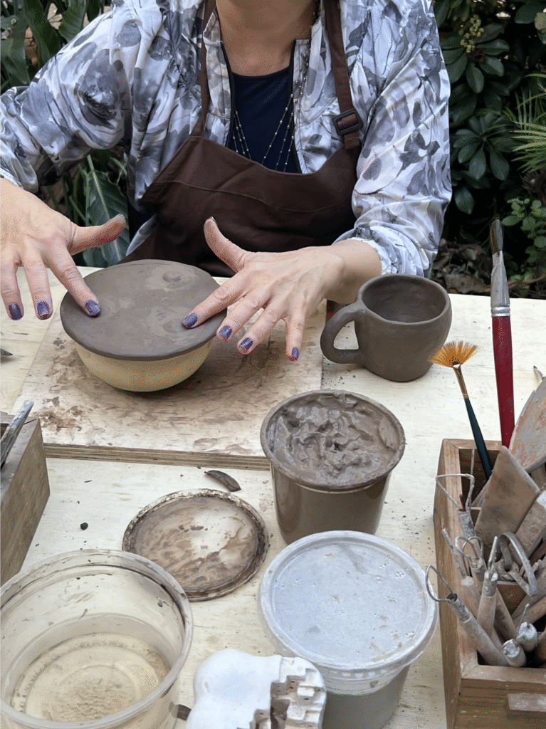 Pessoas modelando peças de cerâmica